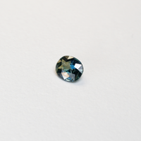 1.25 carat oval parti teal sapphire with mixed green and blue color.
