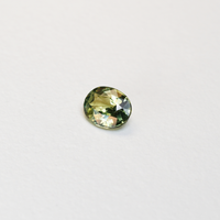 1.30 carat oval parti teal sapphire with mixed green and yellow color.