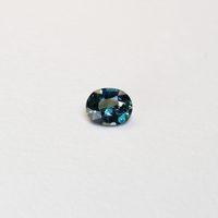1.25 carat oval parti teal sapphire with mixed green and blue color.