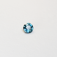 1 carat round parti teal sapphire with mixed green and blue color.