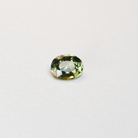 1.30 carat oval parti teal sapphire with mixed green and yellow color.
