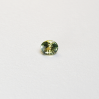 1 carat pear parti teal sapphire with mixed green and yellow color.