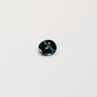 1.1 carat oval parti teal sapphire with mixed green and blue color.