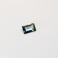 1.1 carat baguette parti teal sapphire with mixed green and blue color.