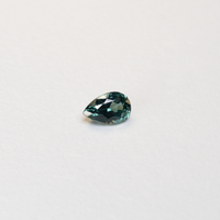 1.1 carat pear parti teal sapphire with mixed green and blue color.