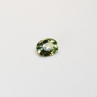 1.30 carat oval parti teal sapphire with mixed green and yellow color.
