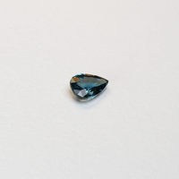 1 carat pear parti teal sapphire with mixed green and blue color.