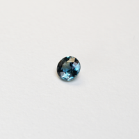 1 carat round parti teal sapphire with mixed green and blue color.