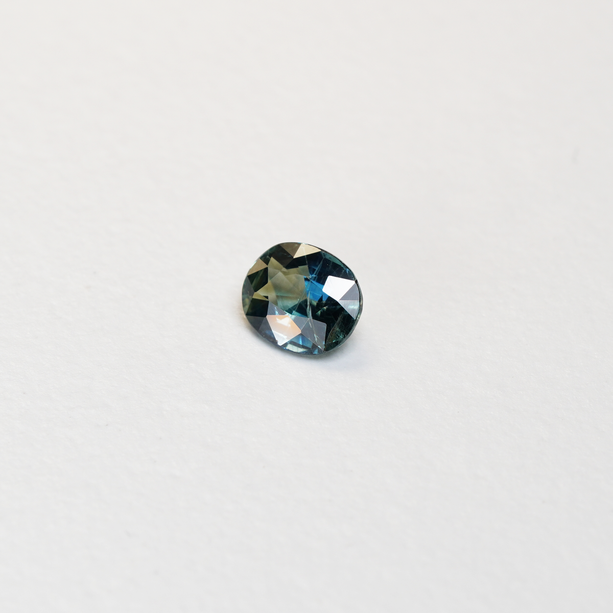 1.25 carat oval parti teal sapphire with mixed green and blue color.