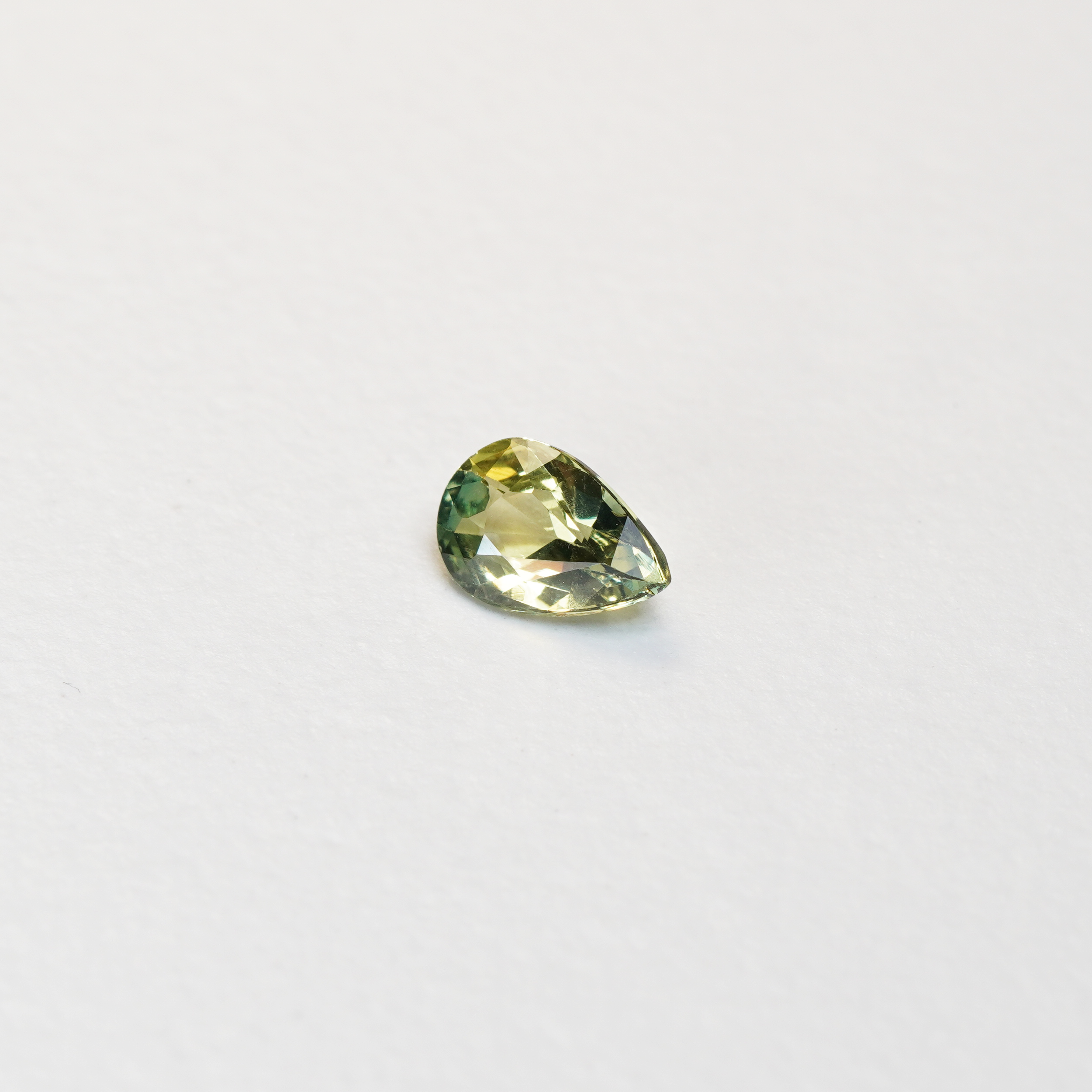 1 carat pear parti teal sapphire with mixed green and yellow color.