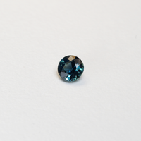 1.3 carat round parti teal sapphire with mixed green and blue color.