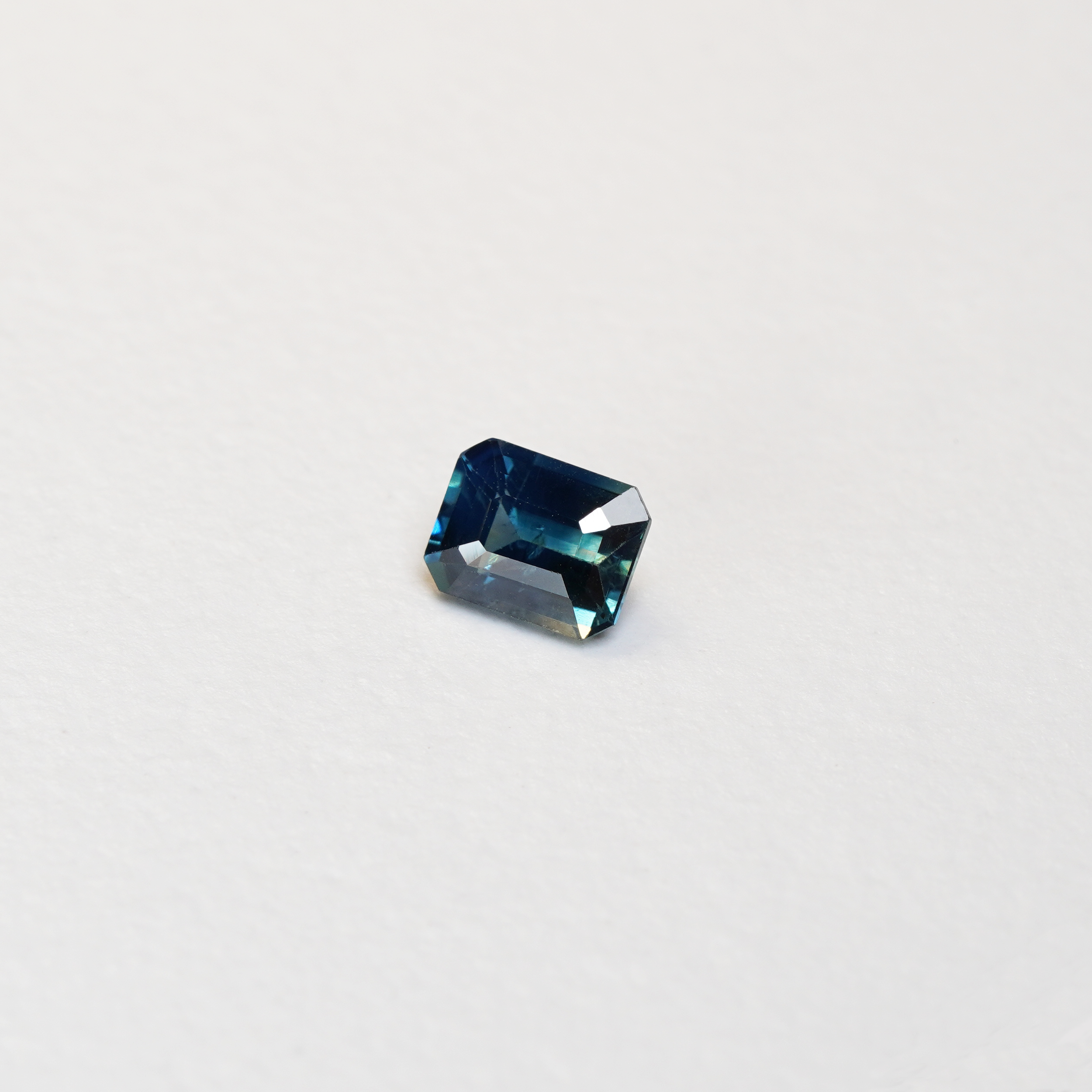 1.1 carat cushion cut parti teal sapphire with mixed green and blue color.