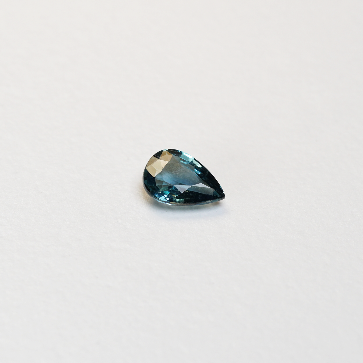 1 carat pear parti teal sapphire with mixed green and blue color.