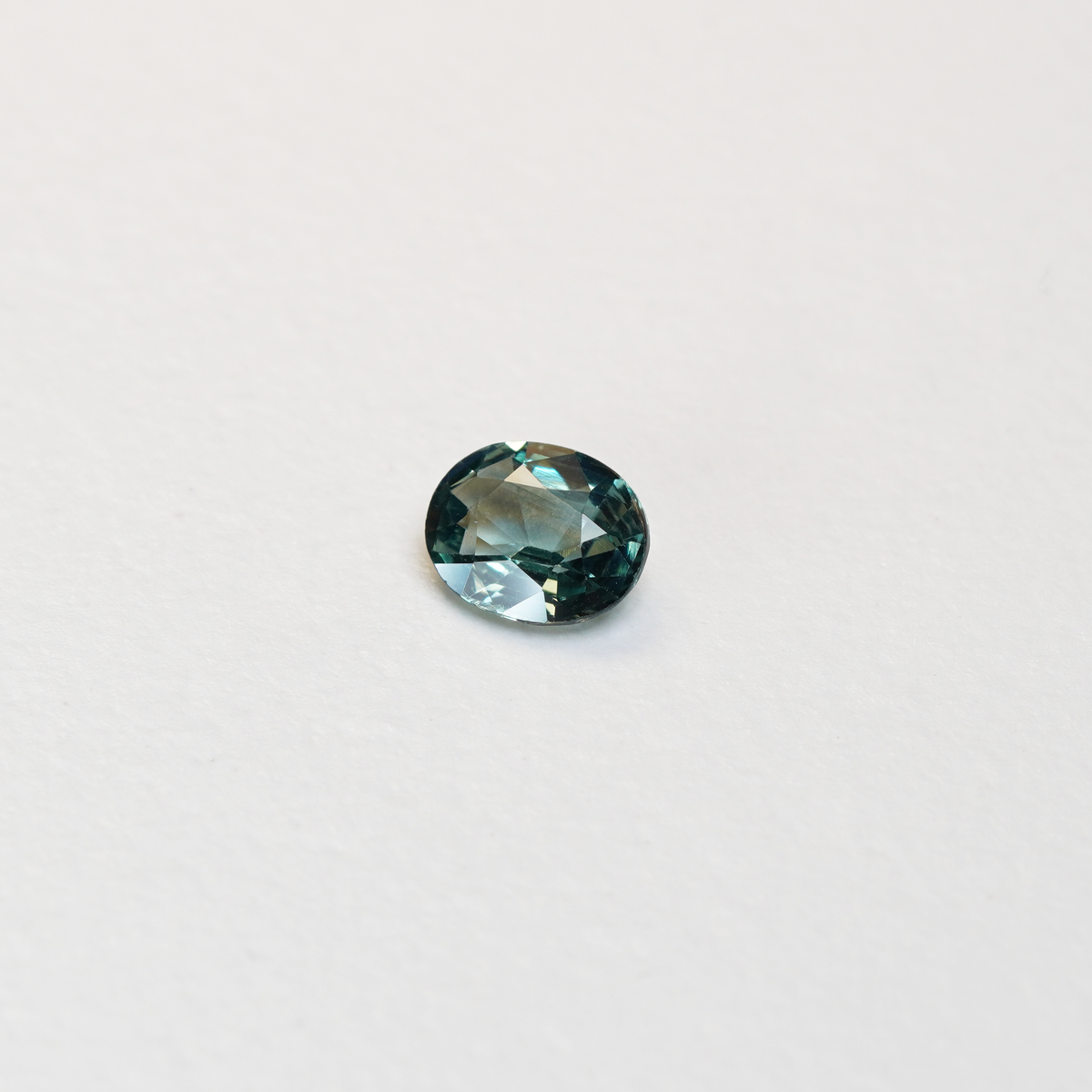 1.10 carat oval parti teal sapphire with mixed green and blue color.