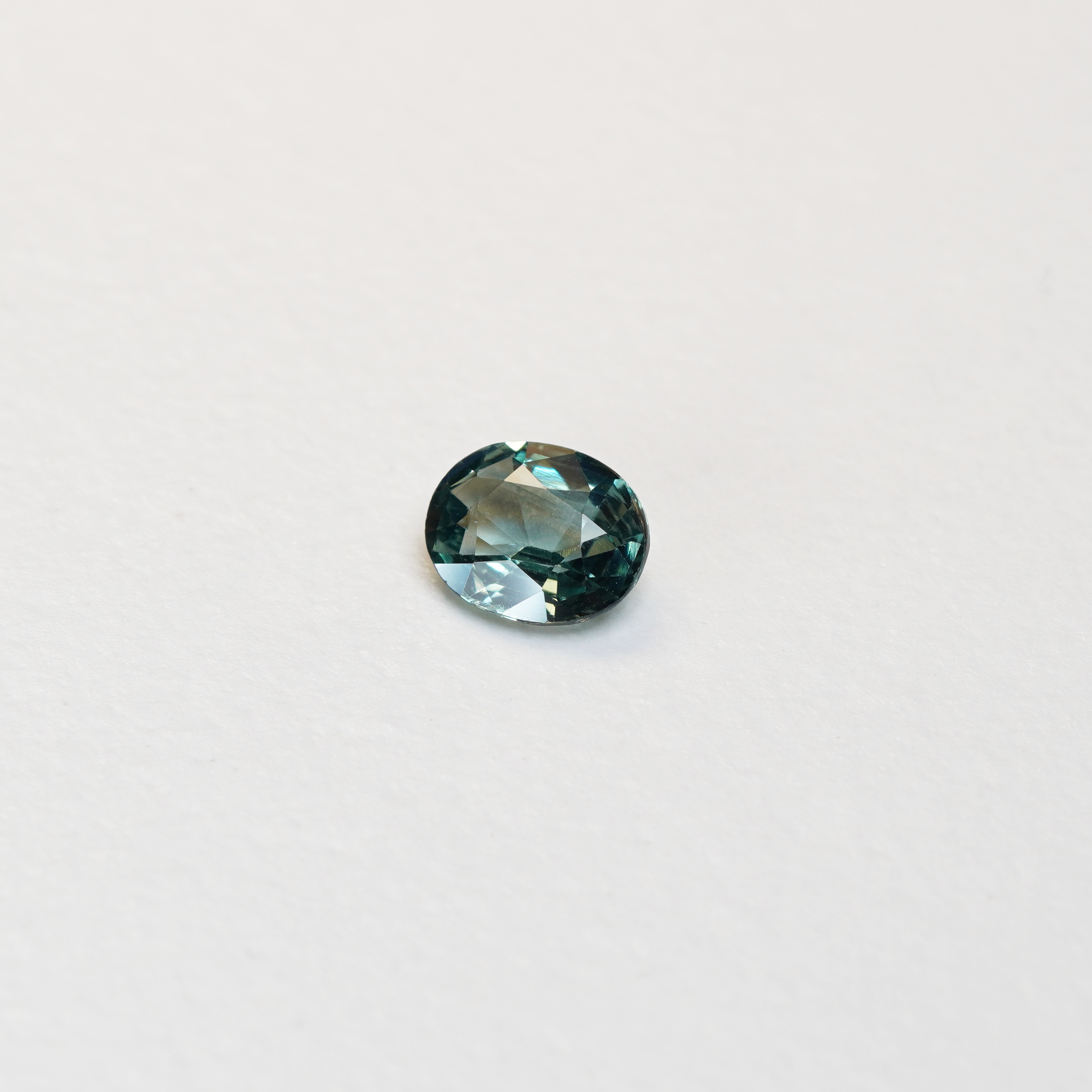 1.10 carat oval parti teal sapphire with mixed green and blue color.
