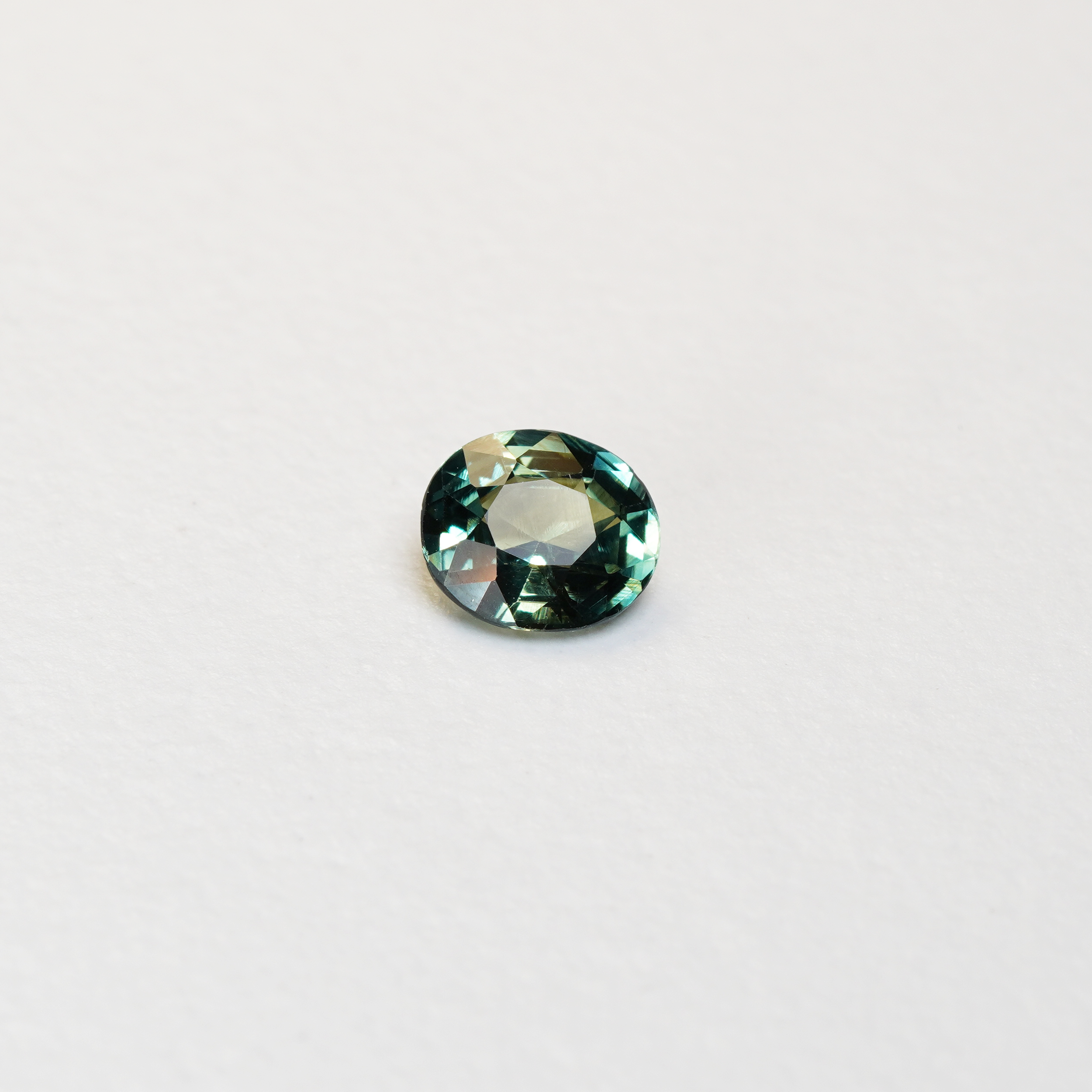 1.3 carat oval parti teal sapphire with mixed green and blue color.