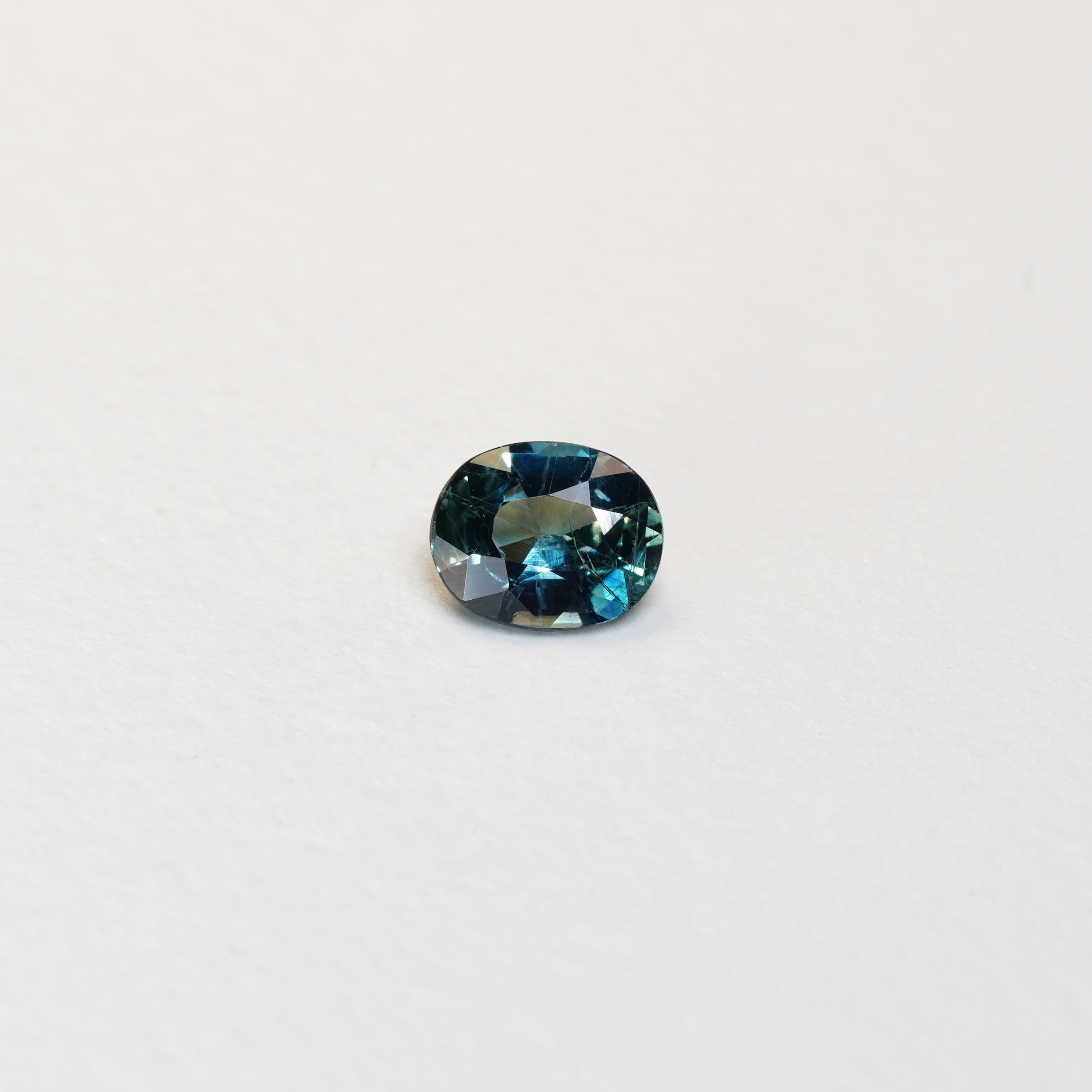 1.25 carat oval parti teal sapphire with mixed green and blue color.