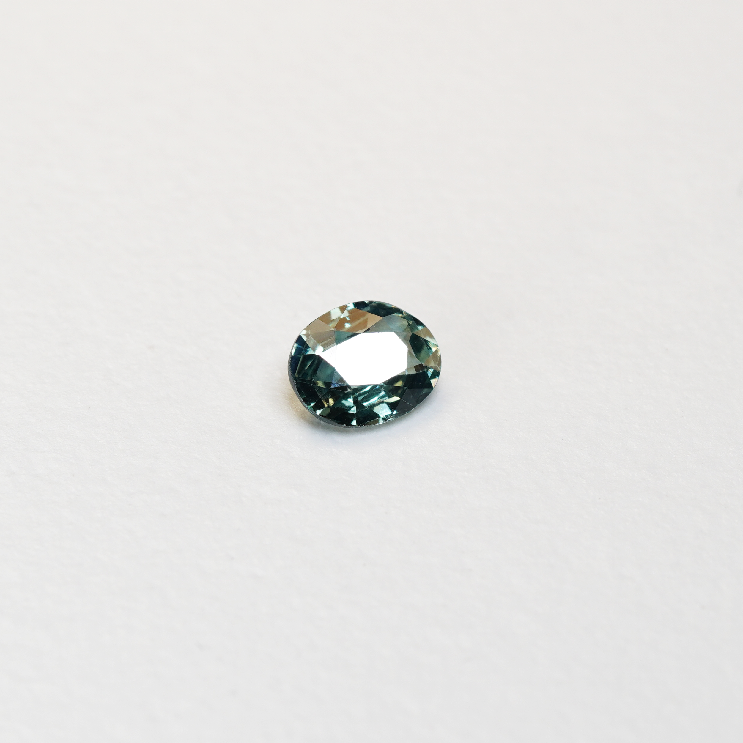 1.10 carat oval parti teal sapphire with mixed green and blue color.