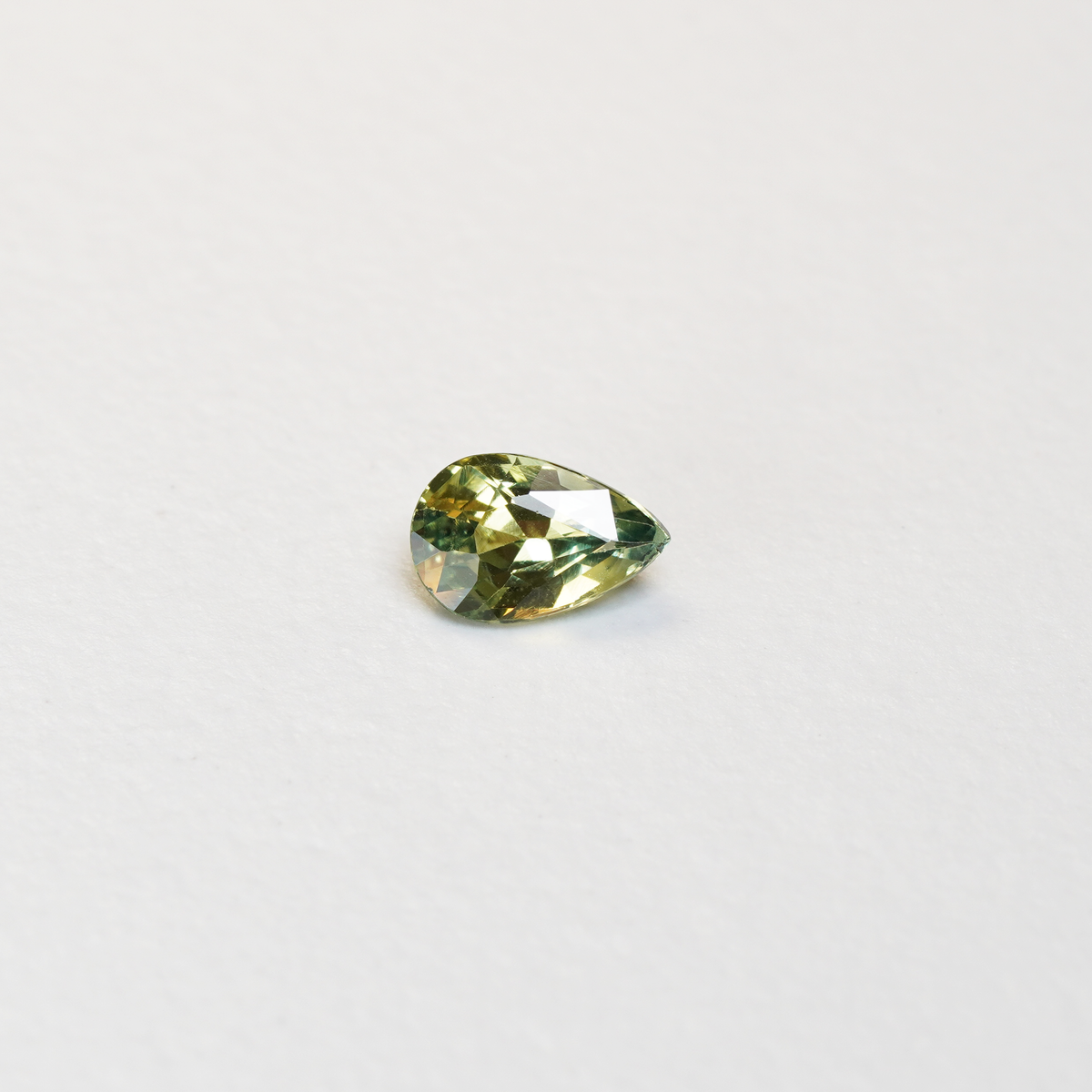 1 carat pear parti teal sapphire with mixed green and yellow color.