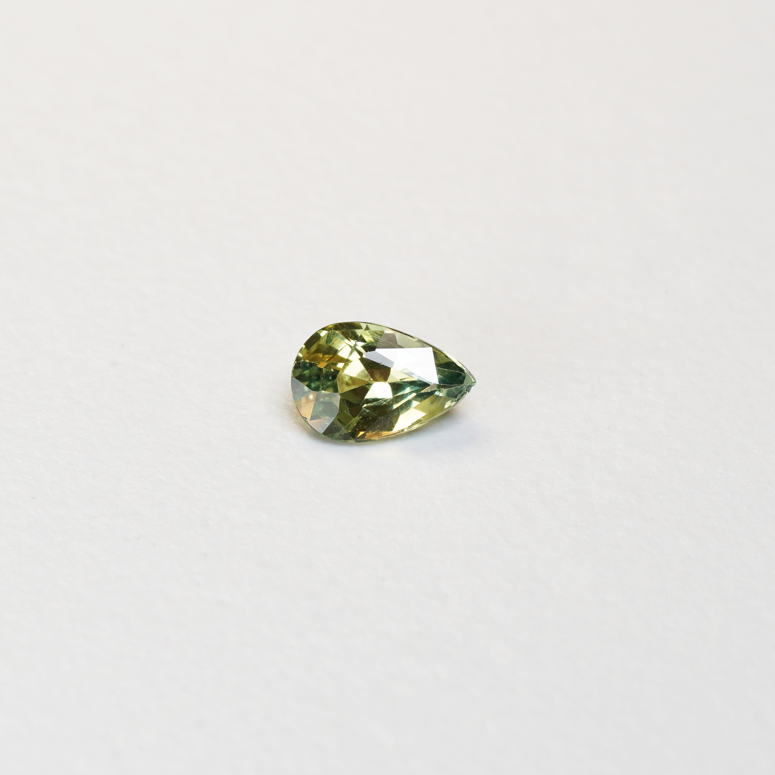 1 carat pear parti teal sapphire with mixed green and yellow color.