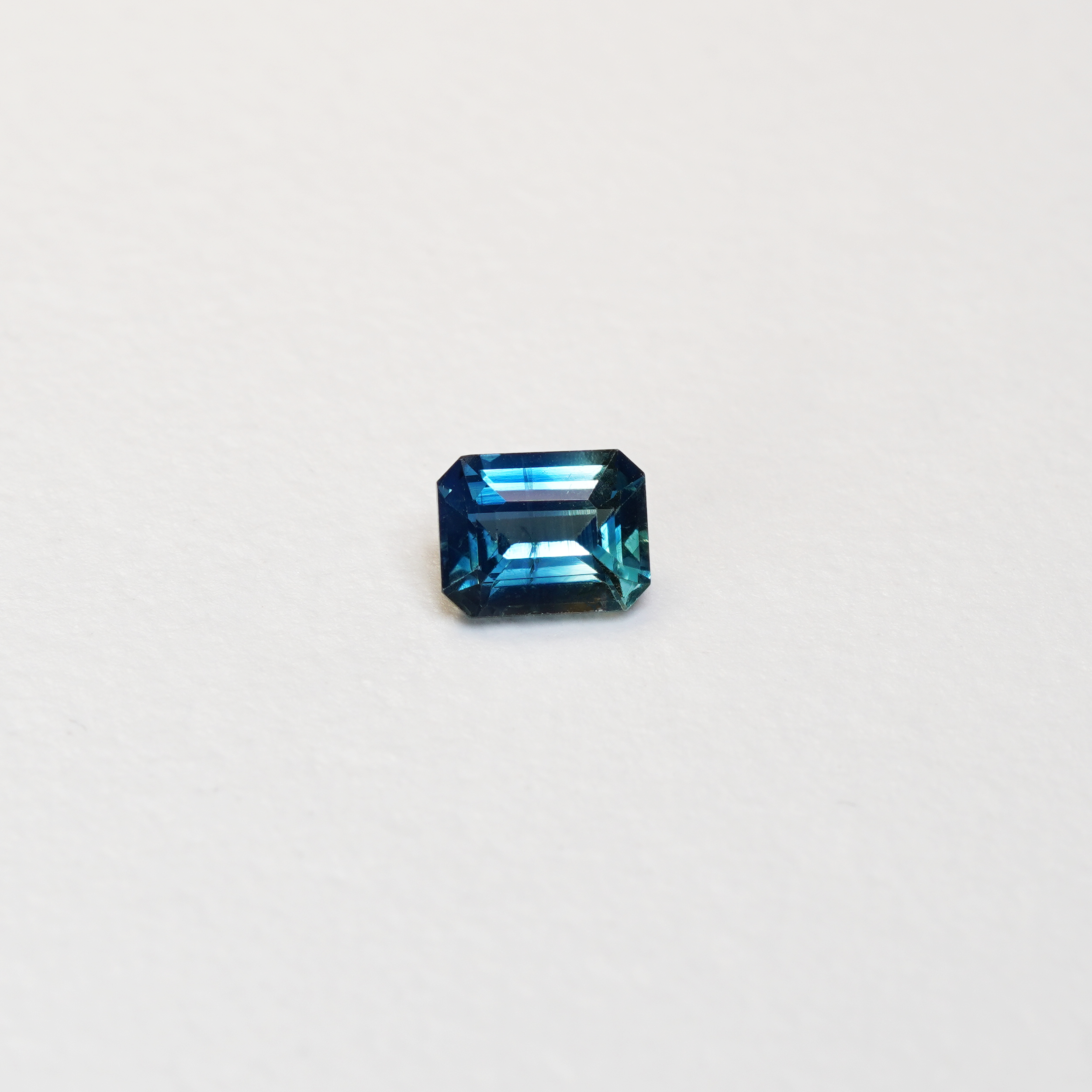 1.1 carat cushion cut parti teal sapphire with mixed green and blue color.