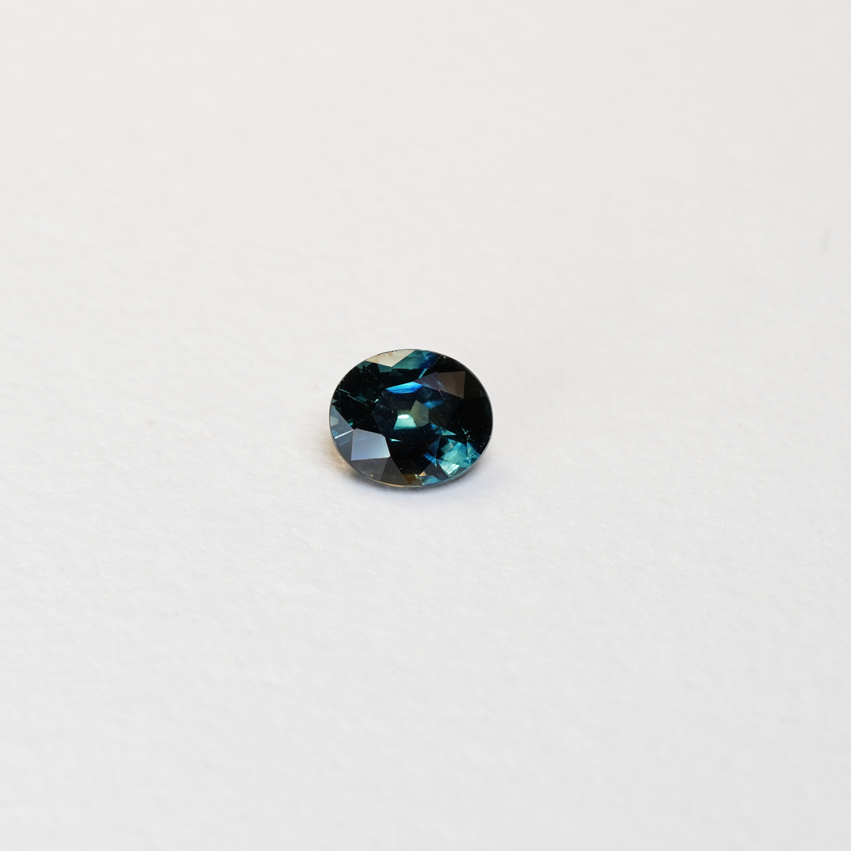 1.1 carat oval parti teal sapphire with mixed green and blue color.