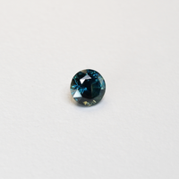 1.76 carat round parti teal sapphire with mixed green and blue color.