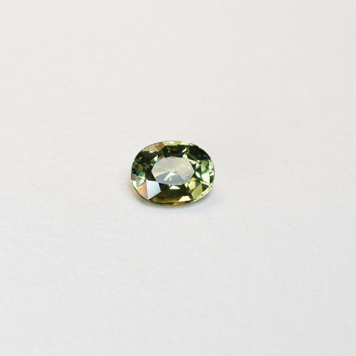 1.30 carat oval parti teal sapphire with mixed green and yellow color.