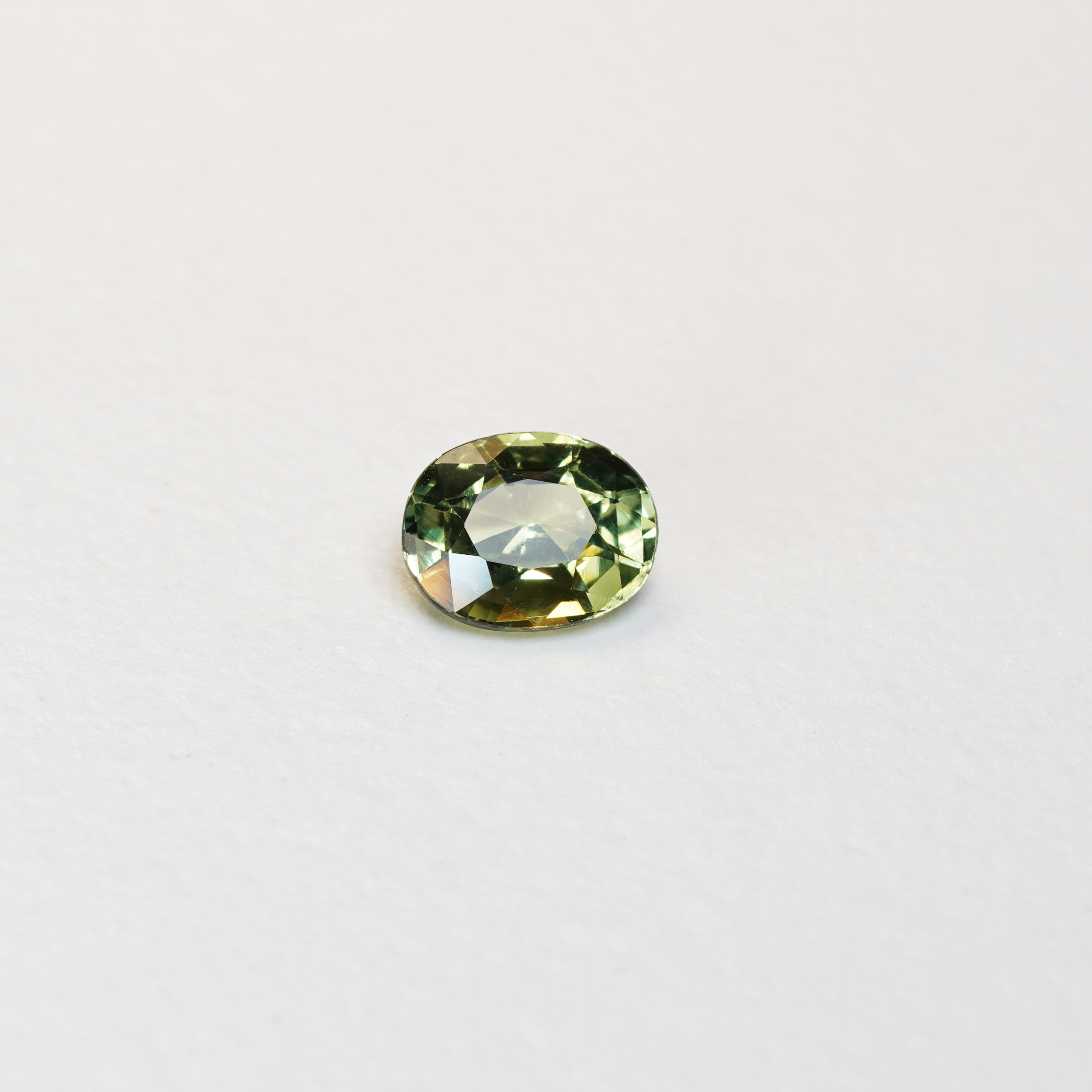 1.30 carat oval parti teal sapphire with mixed green and yellow color.