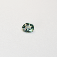 1.10 carat oval parti teal sapphire with mixed green and yellow color.