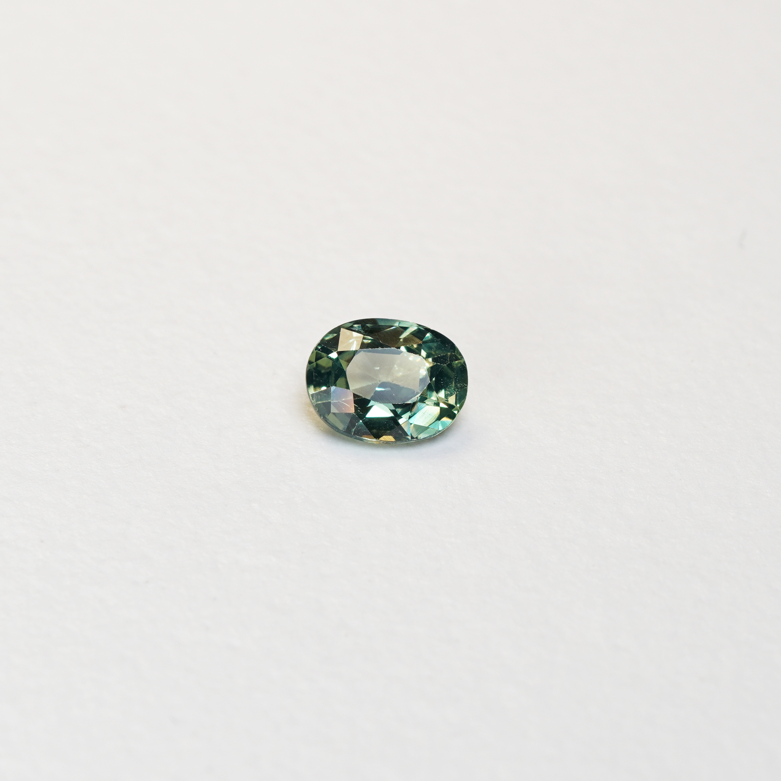 1.10 carat oval parti teal sapphire with mixed green and yellow color.