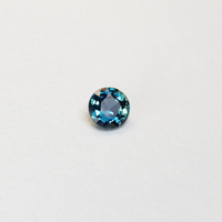 1.3 carat round parti teal sapphire with mixed green and blue color.