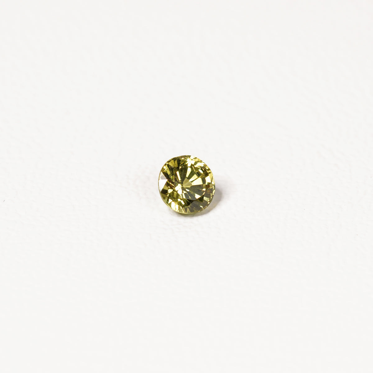 0.95ct Australian yellow-green sapphire round brilliant — vivid lime yellow-green, face-up view — Ruhuna Gemstones