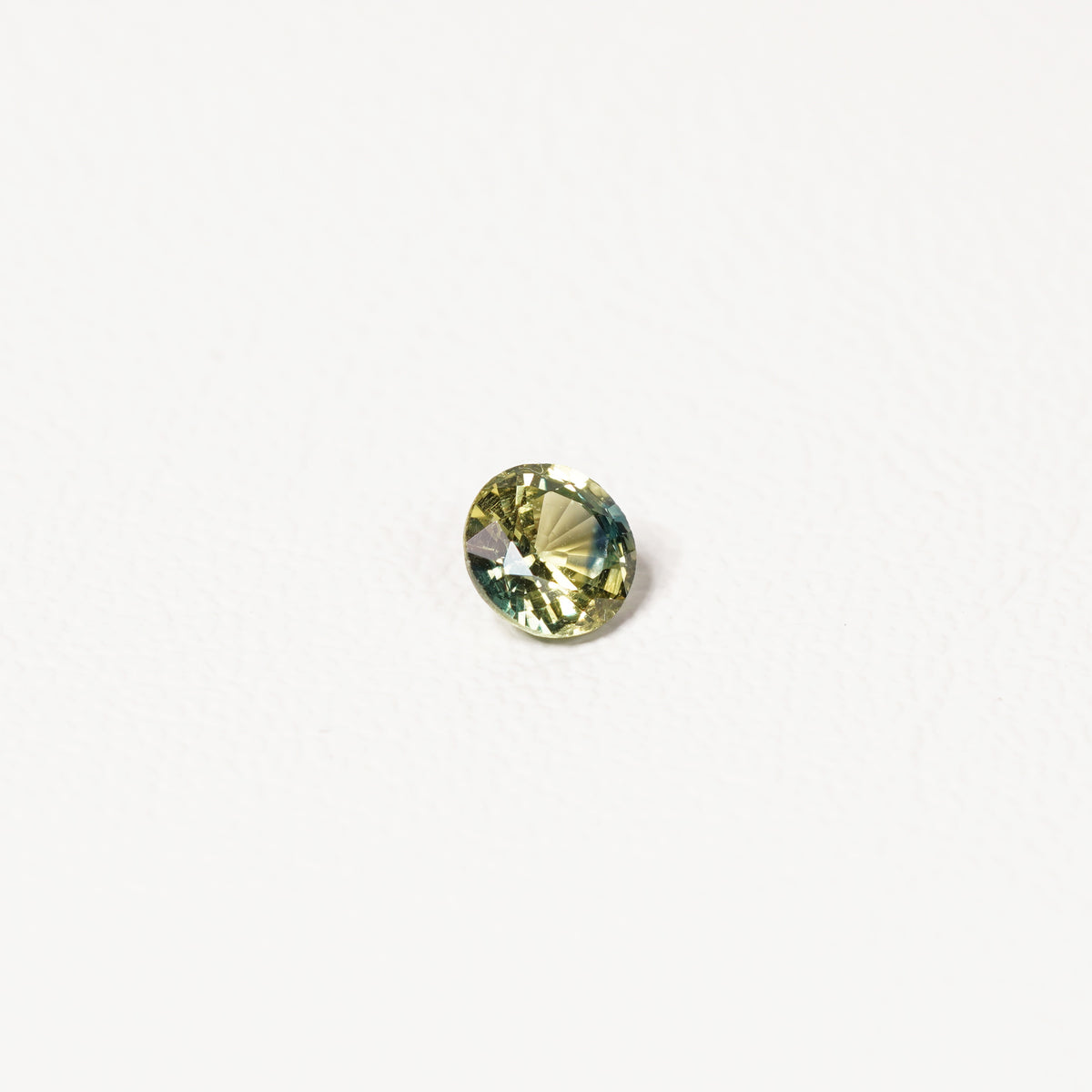 0.90ct Australian parti sapphire round — bright yellow-green body with teal crown accent, face-up — Ruhuna Gemstones