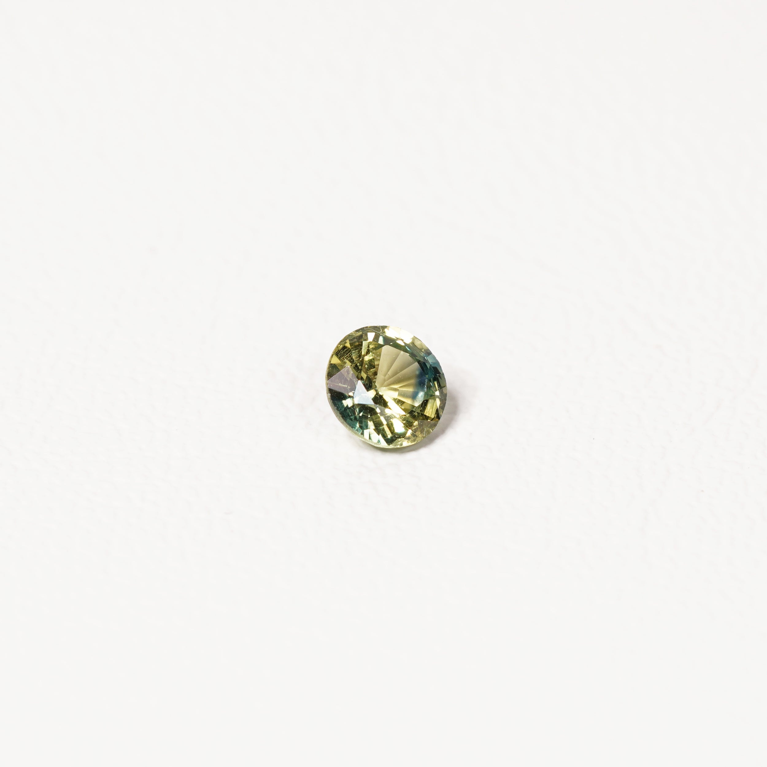 0.90ct Australian parti sapphire round — bright yellow-green body with teal crown accent, face-up — Ruhuna Gemstones