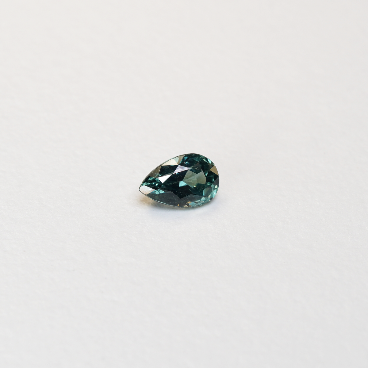 1.1 carat pear parti teal sapphire with mixed green and blue color.
