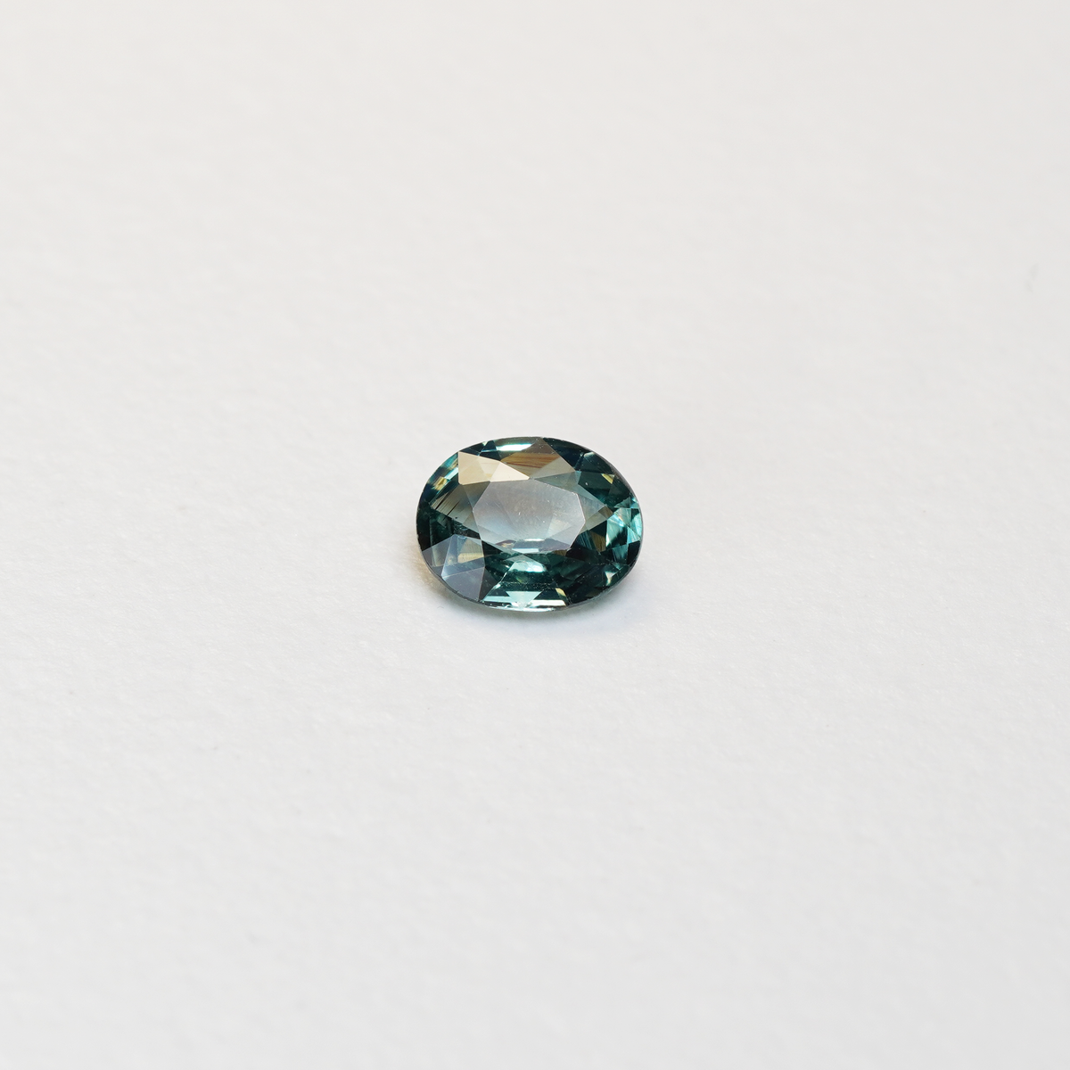 1.10 carat oval parti teal sapphire with mixed green and blue color.