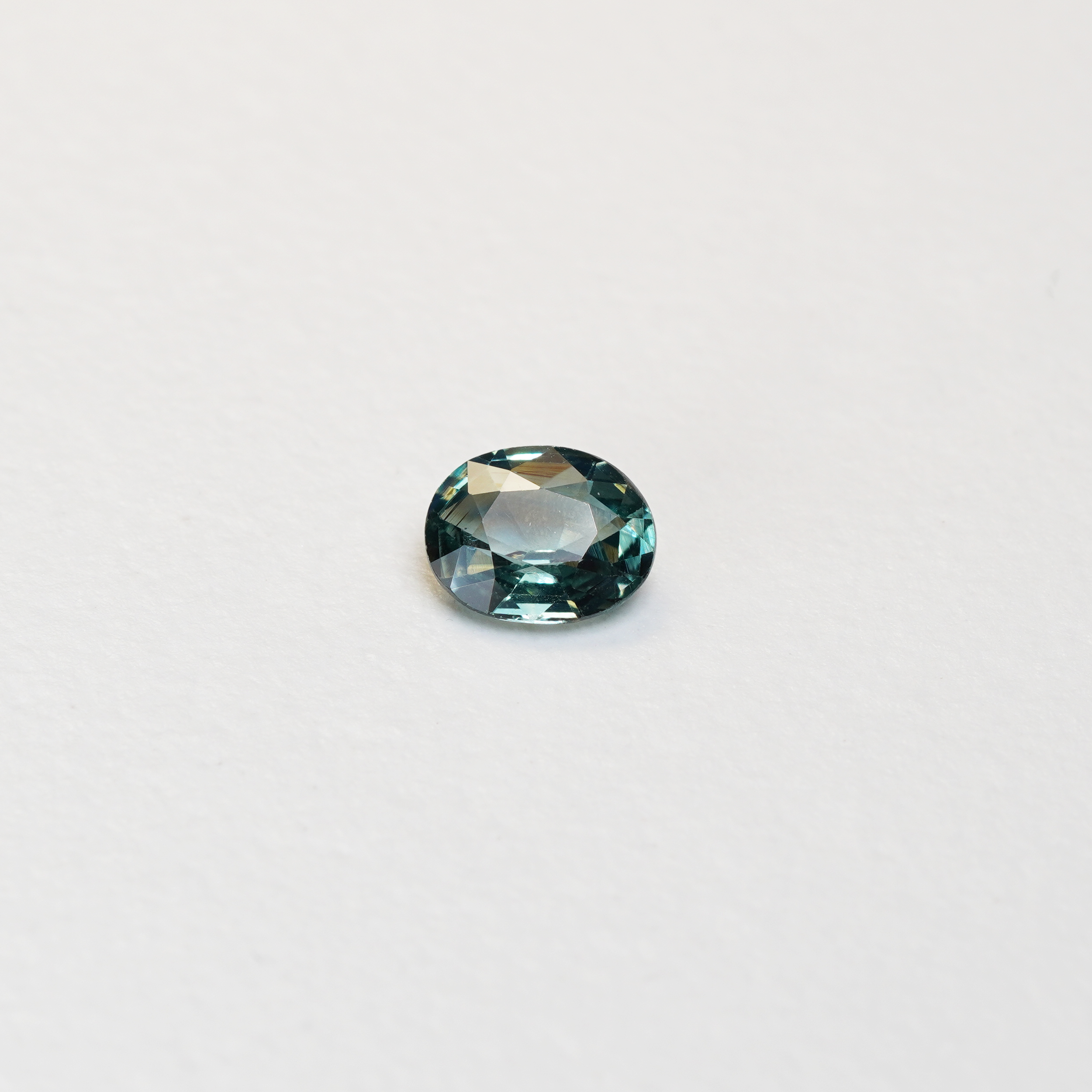 1.10 carat oval parti teal sapphire with mixed green and blue color.