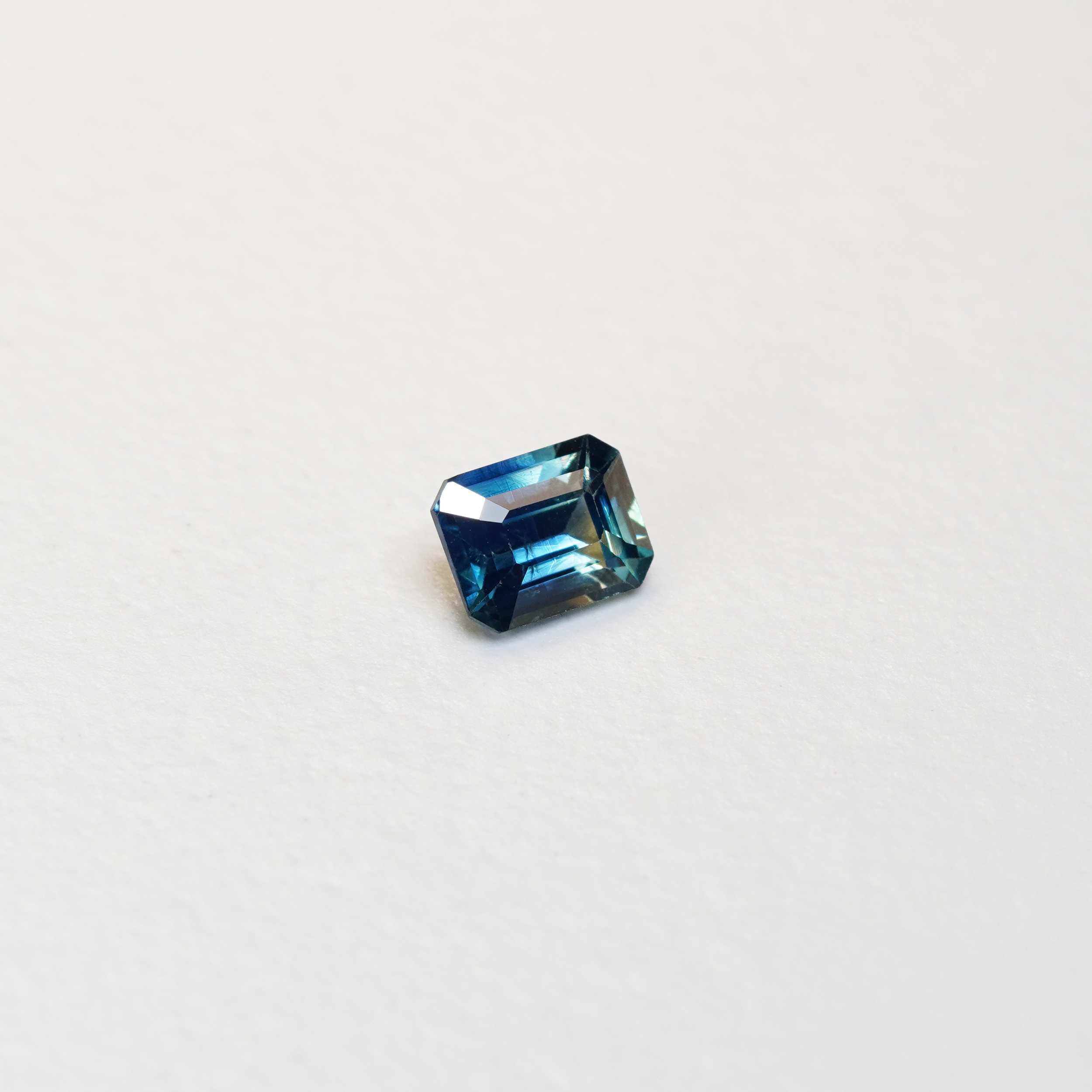 1.1 carat cushion cut parti teal sapphire with mixed green and blue color.