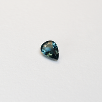 1 carat pear parti teal sapphire with mixed green and blue color.