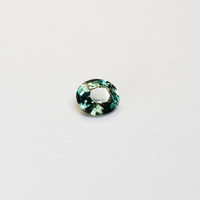 1.3 carat oval parti teal sapphire with mixed green and blue color.