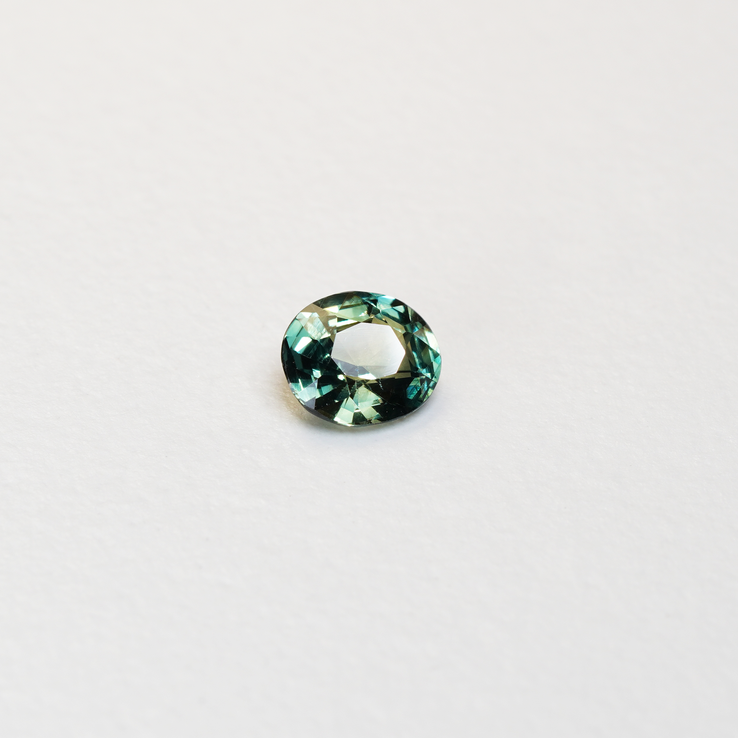 1.3 carat oval parti teal sapphire with mixed green and blue color.