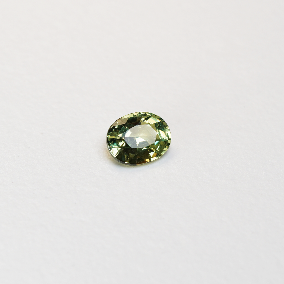 1.30 carat oval parti teal sapphire with mixed green and yellow color.