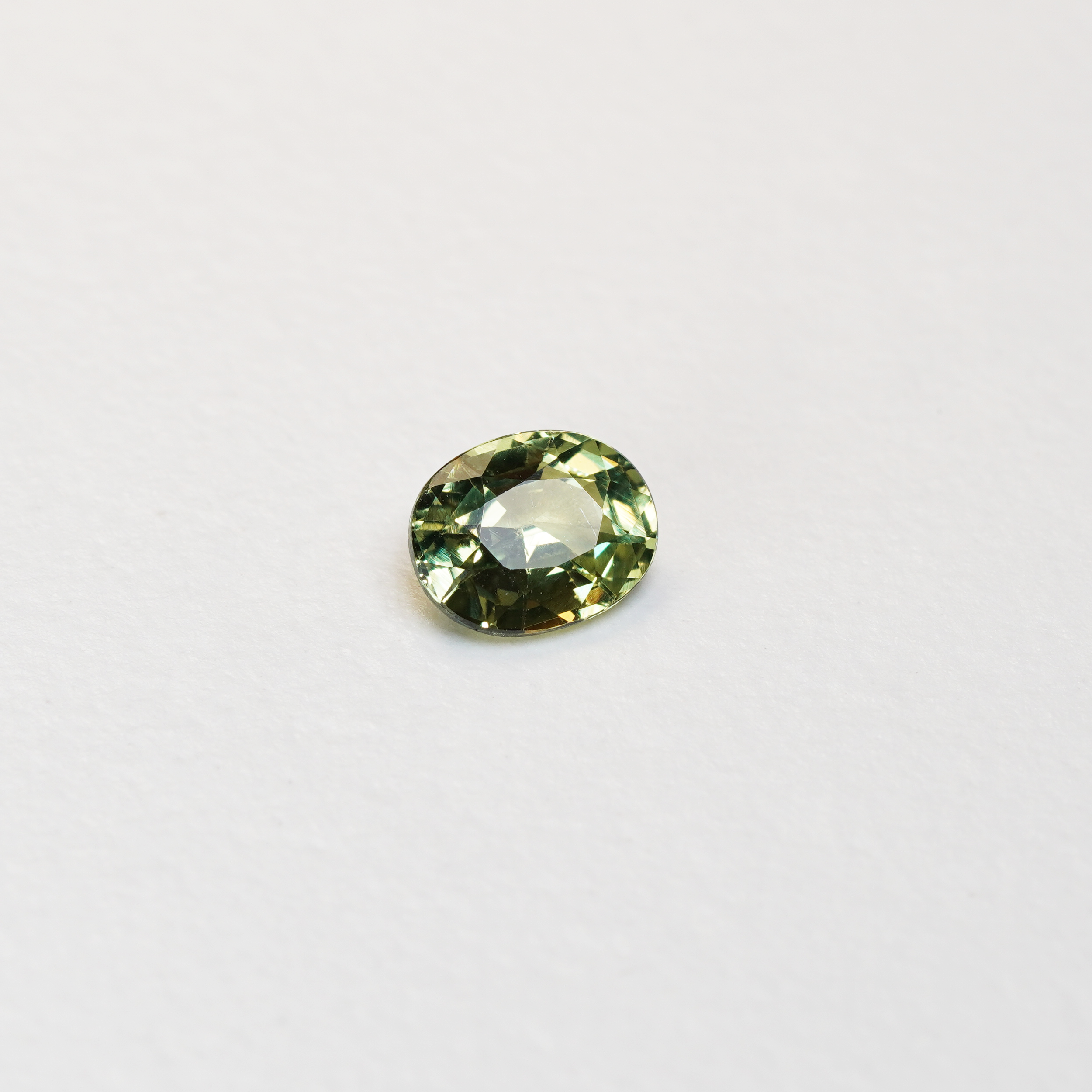 1.30 carat oval parti teal sapphire with mixed green and yellow color.