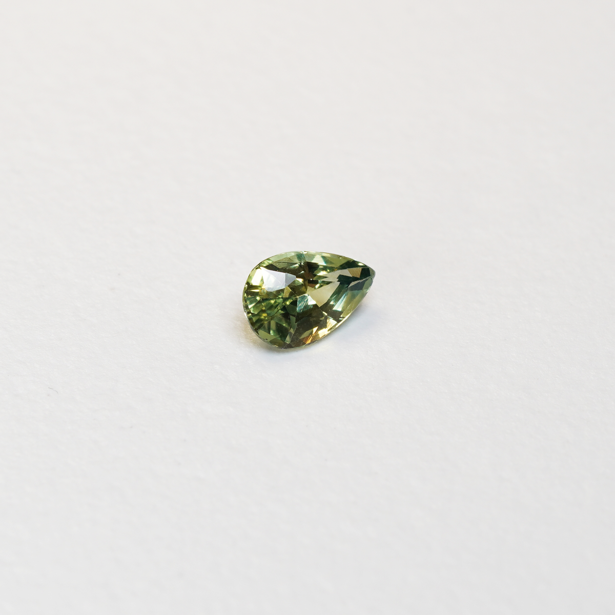 1 carat pear parti teal sapphire with mixed green and yellow color.
