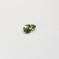 1 carat pear parti teal sapphire with mixed green and yellow color.