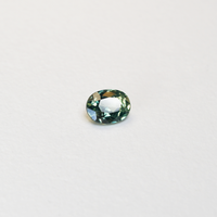 1.10 carat oval parti teal sapphire with mixed green and yellow color.