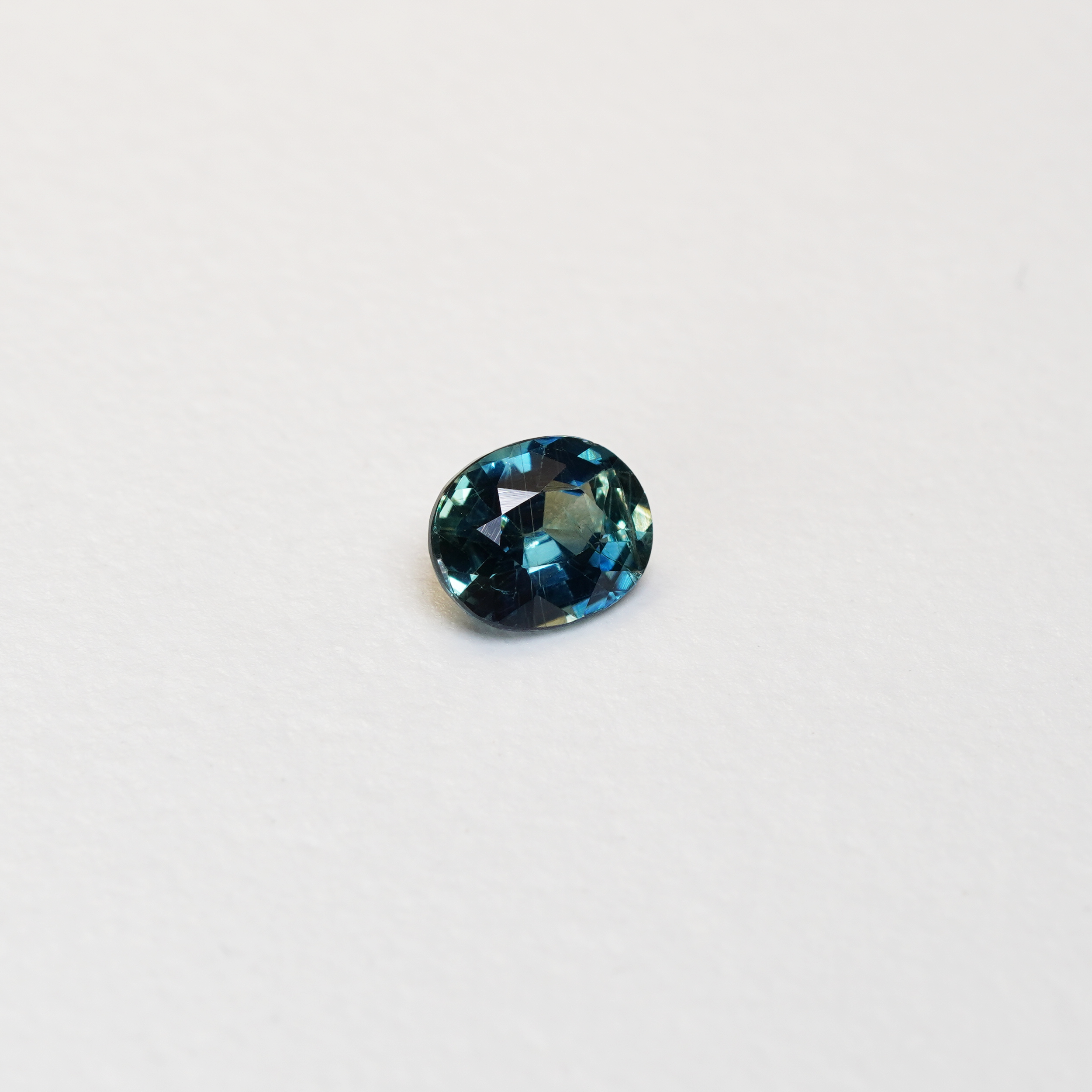 1.25 carat oval parti teal sapphire with mixed green and blue color.