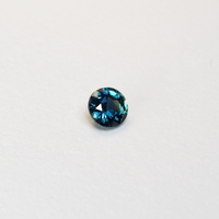 1.3 carat round parti teal sapphire with mixed green and blue color.