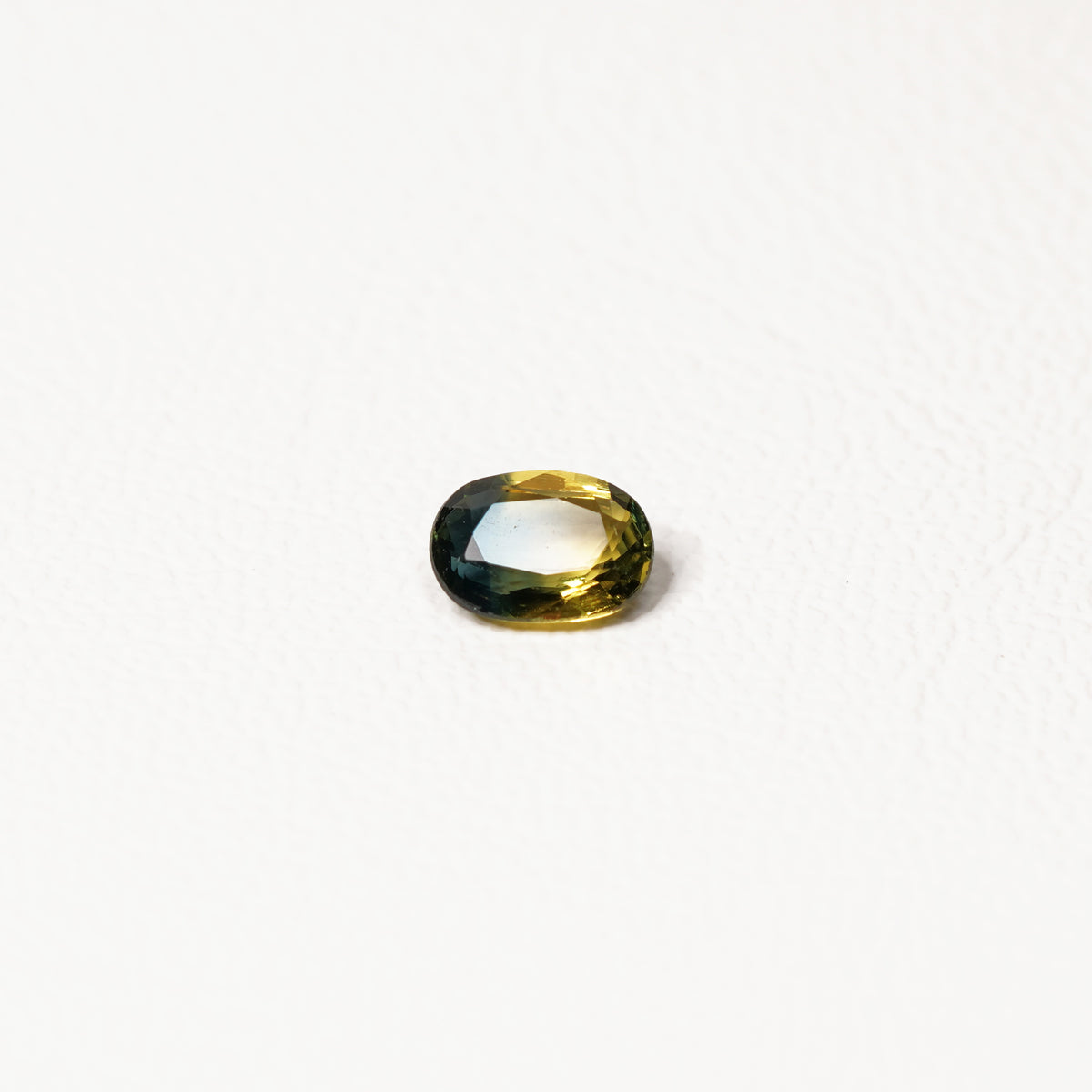 0.90ct Australian parti sapphire oval — golden yellow and teal-green colour zones, face-up — Ruhuna Gemstones